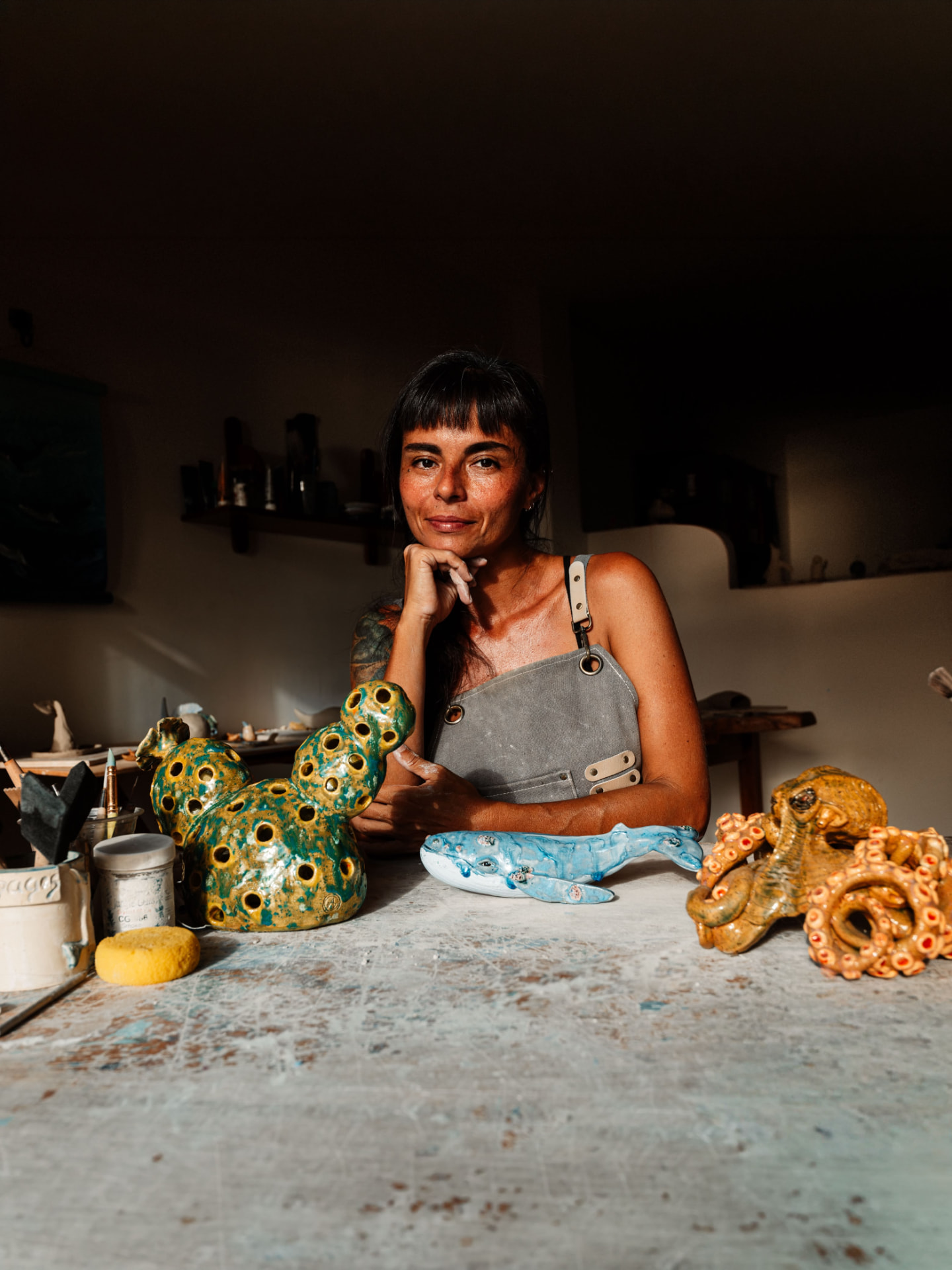 Belén Vásquez en su taller, junto a sus esculturas de cerámica: una ballena, un pulpo y una pieza de coral