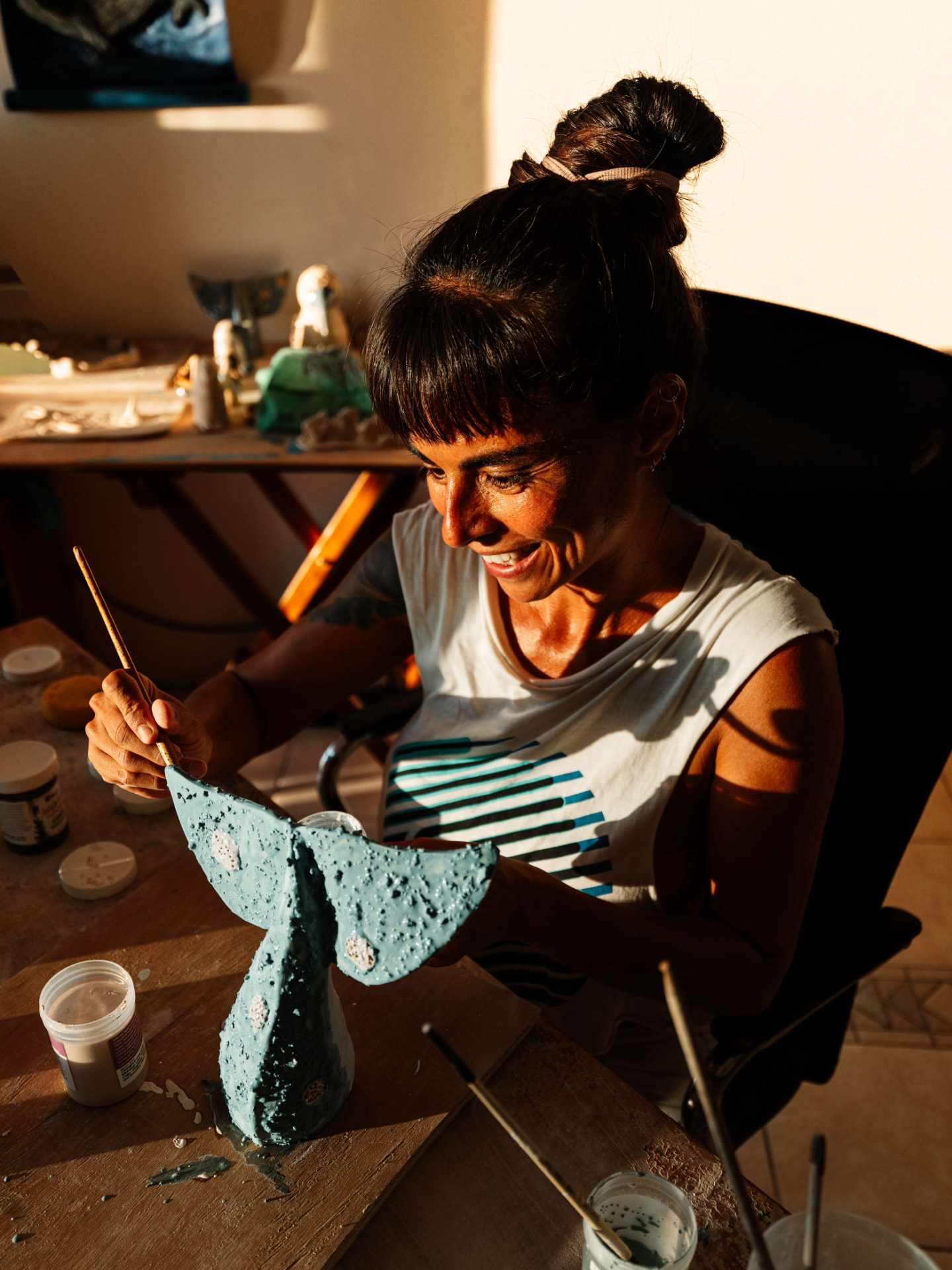 Belén Vásquez pintando una escultura de cerámica en el taller de Octopus Art Gallery